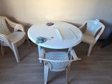 une table et des chaises blanches dans un coin de la pièce