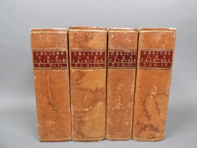 four old books sitting on top of each other on a table