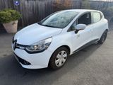une voiture blanche garée sur un parking près d'une clôture en bois
