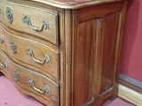 a wooden chest of drawers in the corner of a room