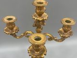 a gold candelab with three candles on it