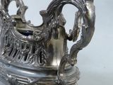a silver teapot with a handle on a stand