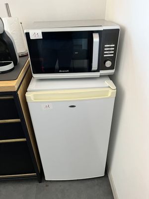 un micro-ondes et un petit réfrigérateur dans un coin de la pièce