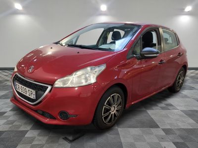 la voiture rouge est garée sur un sol en damier dans le garage