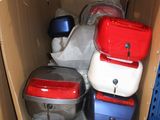 de nombreuses valises rangées dans un carton posé sur une étagère
