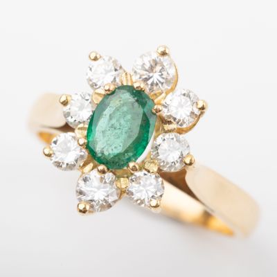 an image of a green emerald and diamond ring on a white background
