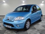 la petite voiture bleue est garée sur un sol en damier