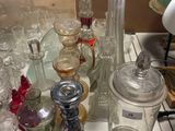 many glass jars on a table with a lamp on it
