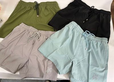 quatre paires de shorts de bain pour homme posées sur une table