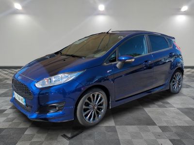 a blue ford fiesta parked on a checkered floor in a garage