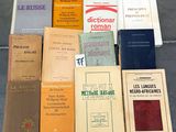 Plusieurs livres sont posés par terre, les uns à côté des autres.