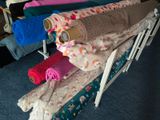 many towels and blankets stacked on a rack in a room