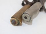 two bullet shells on a white surface next to each other