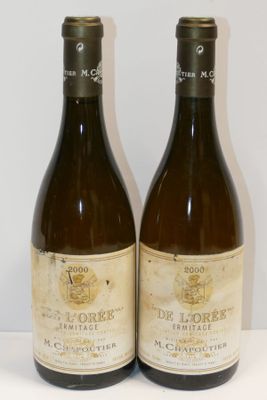 deux bouteilles de vin posées sur une table l'une à côté de l'autre