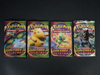 trois paquets de cartes à collectionner Pokémon posés sur une table