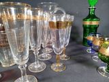 many wine glasses sitting on a table next to a green bottle