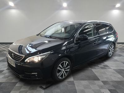 une voiture noire est garée dans une pièce au sol en damier