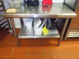 une table en acier inoxydable sur laquelle sont posés tout un tas de plats