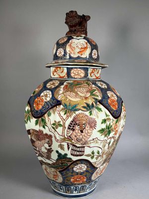 a large vase with a lid that has flowers and birds on it