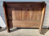 a wooden bed frame with a wooden headboard on it