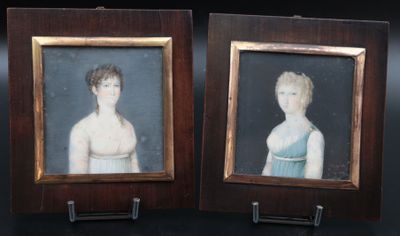 two framed portraits of a boy and a girl in a blue dress