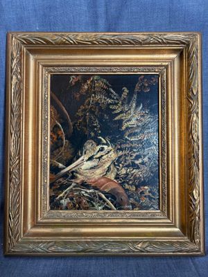 tableau représentant un oiseau dans un cadre doré sur fond bleu