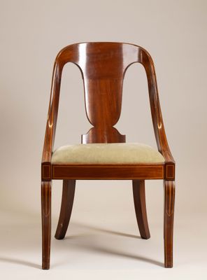 le dossier d'une chaise en bois sur laquelle est posé un coussin vert