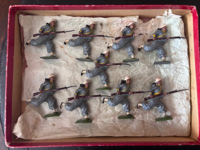 de nombreux petits soldats dans une boîte posée sur une table