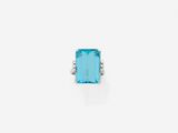 a blue topaz stone and diamond ring on a white background