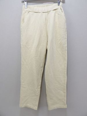 a white pants hanging on a hanger against a wall