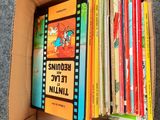 a box full of children ' s books sitting on top of a carpet