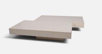 une table basse blanche avec un plateau carré sur fond blanc