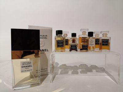 trois flacons de parfum Chanel posés sur une table à côté d'une boîte de parfums
