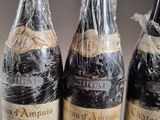 three bottles of wine wrapped in plastic wrap sitting on a table