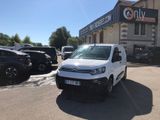 La camionnette blanche est garée devant un immeuble devant lequel sont garées des voitures.