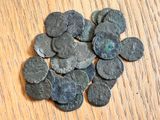 un tas de vieilles pièces romaines posées sur une table en bois