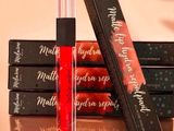 three lipsticks are sitting on a table next to a box of lipstick