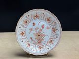 a white plate with orange flowers on it sitting on a table