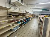 de nombreuses étagères vides dans un magasin, posées à même le sol