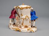 a figurine of three people standing on a pedestal