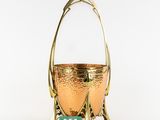 a gold metal basket with handles and handles on a white background