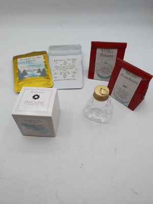 une bouteille de liquide, un récipient contenant du thé et une boîte de sachets de thé