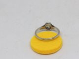 a close up of a ring on a yellow sponge on a white surface