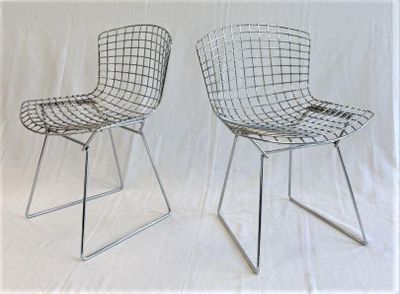 pair of chrome wire chairs on a white background with a white backdrop