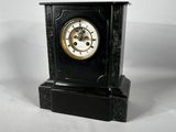 a black clock that is sitting on a white surface