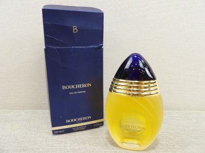 a close up of a bottle of perfume next to a box