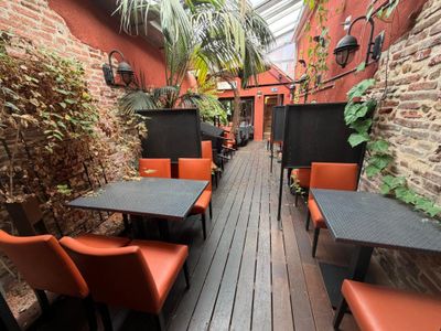 many tables and chairs on the wooden floor of this restaurant