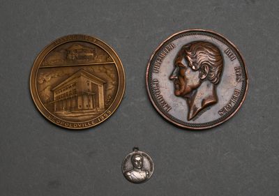 two coins are shown next to each other on a gray surface
