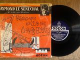 un vieux disque posé sur une table en bois à côté d'un piano