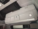a bed in the back of a bus with a black cover